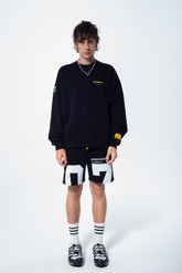 Model in the Haresquare Superhuman black sweatshirt with yellow print, styled with Haresquare black shorts – unisex luxury streetwear from Ireland.
